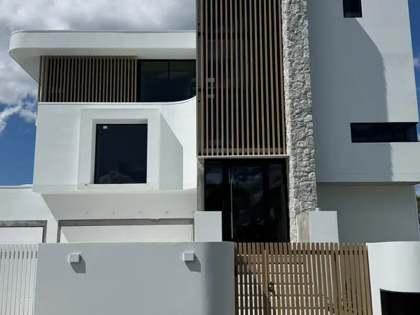Full-height woodgrain aluminium batten screen and matching gate at a home entry