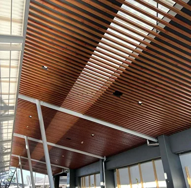 Woodgrain aluminium battens lining a high pavilion ceiling