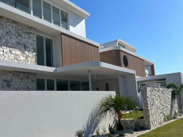 Two-storey homes with woodgrain aluminium battens over stone and white render
