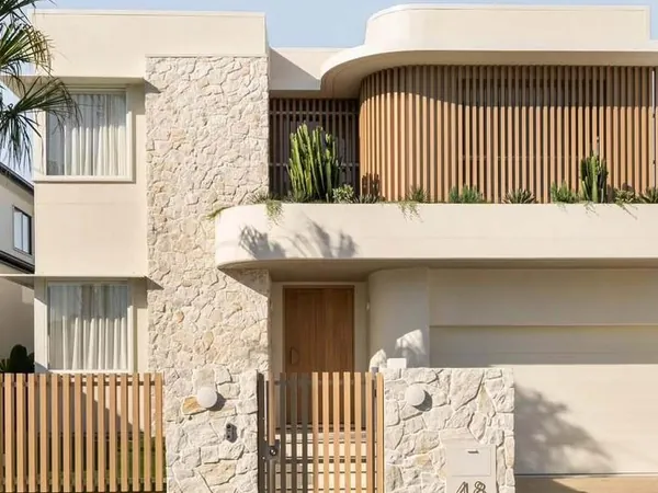 Stone and render facade with woodgrain aluminium battens to the balcony and gate